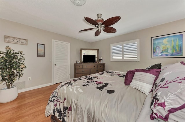 bedroom featuring a closet, ceiling fan, baseboards, and wood finished floors