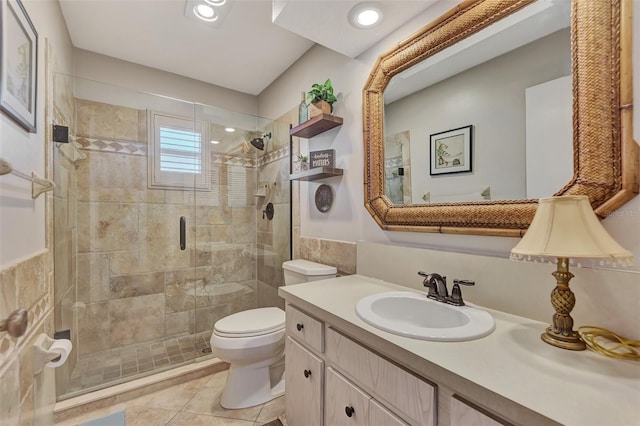 full bath featuring a shower stall, toilet, vanity, tile patterned floors, and tile walls