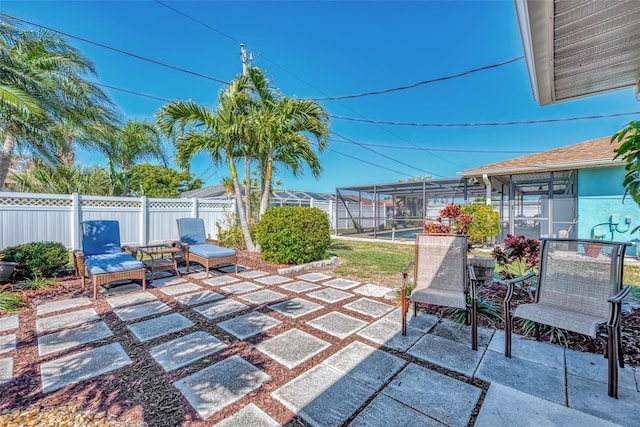 view of patio with a lanai and fence