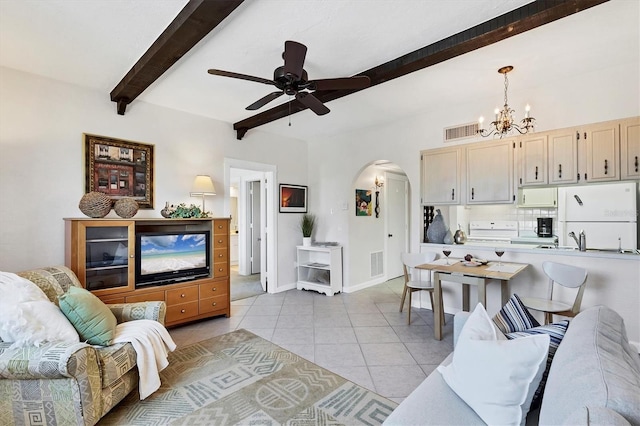 living area featuring beamed ceiling, light tile patterned floors, arched walkways, and visible vents