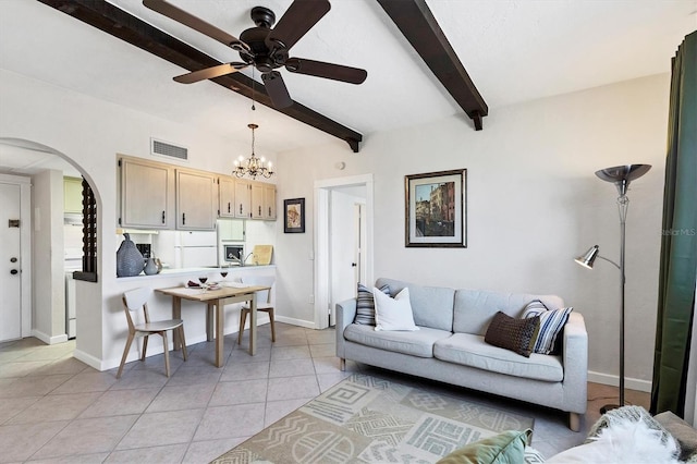 living area with visible vents, baseboards, light tile patterned floors, beam ceiling, and arched walkways