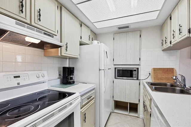 kitchen featuring visible vents, a sink, under cabinet range hood, white appliances, and light tile patterned flooring