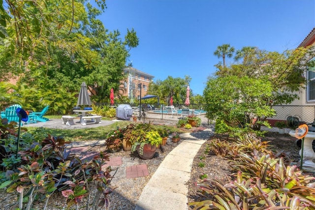 view of yard featuring a patio area, fence, and an outdoor pool