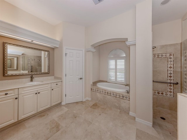 bathroom featuring a walk in shower, vanity, a garden tub, and decorative columns