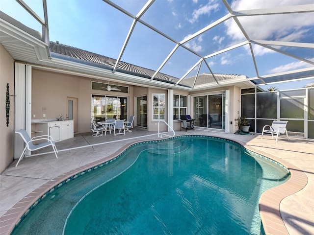 pool with a patio, a lanai, and ceiling fan