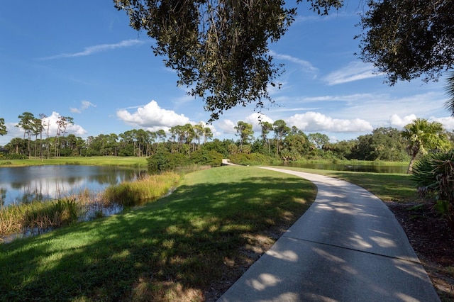 view of property's community featuring a lawn and a water view