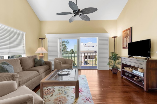 living area featuring lofted ceiling, dark wood-type flooring, and a ceiling fan