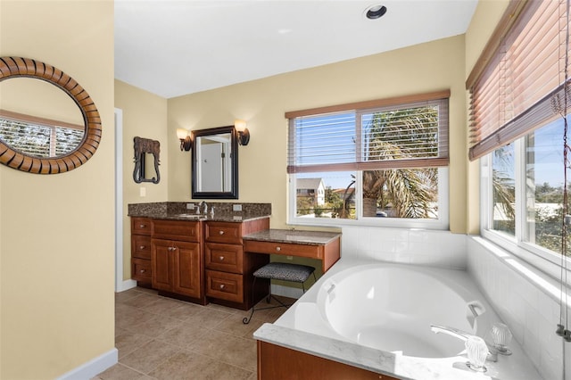 bathroom with a wealth of natural light, a bath, vanity, and tile patterned flooring