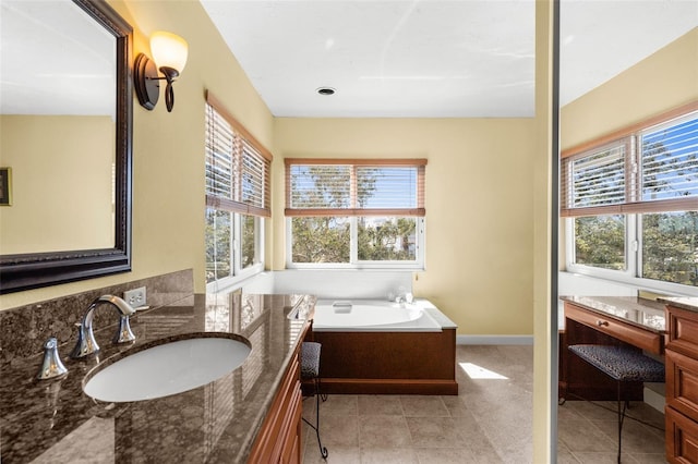 bathroom featuring vanity, a garden tub, baseboards, and tile patterned flooring