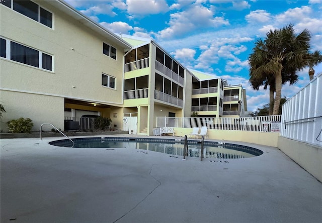 pool with a patio area and fence