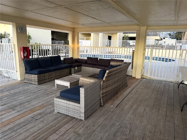 wooden terrace with outdoor lounge area, a pool, and fence