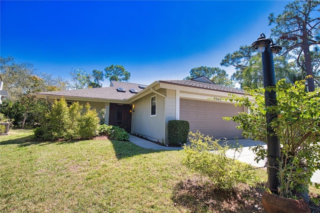 ranch-style home featuring a garage, a front yard, and a shingled roof