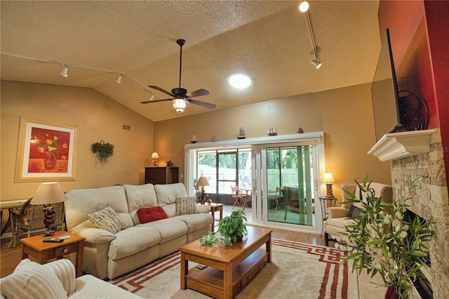 living area with a textured ceiling, wood finished floors, ceiling fan, and vaulted ceiling