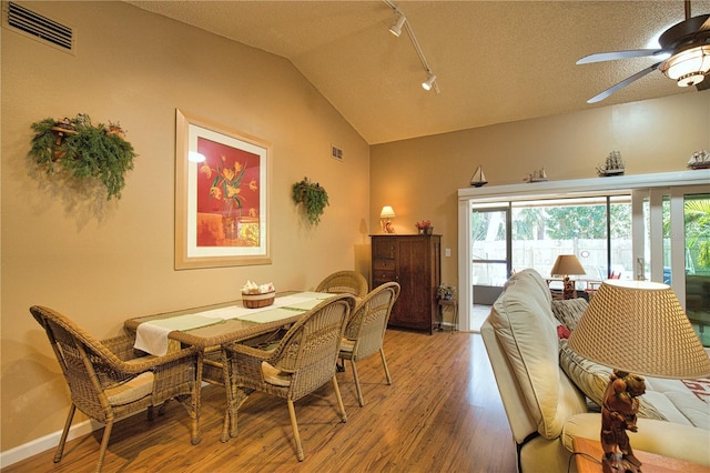 dining room with light wood finished floors, visible vents, a healthy amount of sunlight, and lofted ceiling