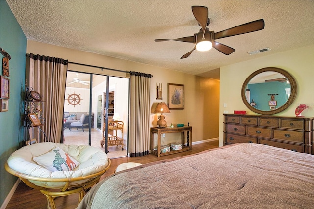 bedroom featuring a ceiling fan, wood finished floors, visible vents, baseboards, and access to exterior