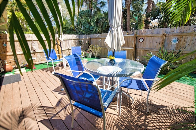 deck with outdoor dining area and fence