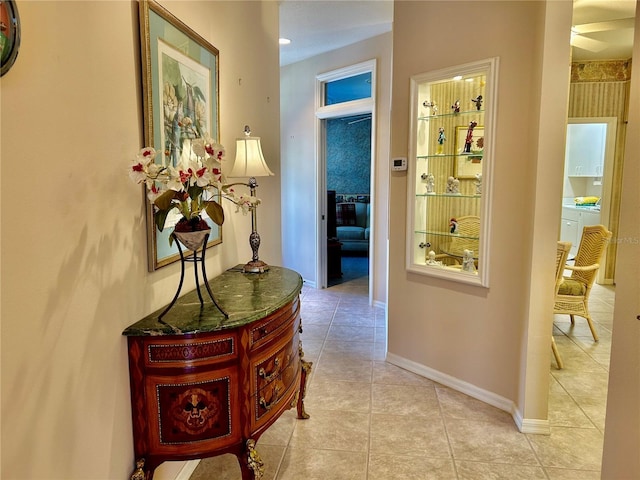 hall with light tile patterned floors and baseboards