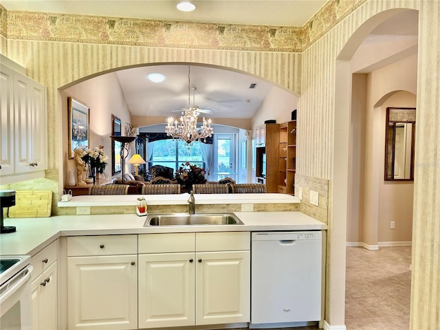 kitchen with a sink, white appliances, light countertops, a chandelier, and vaulted ceiling