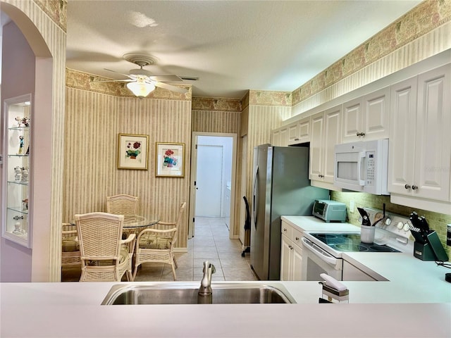 kitchen featuring light countertops, white cabinets, white appliances, a textured ceiling, and a ceiling fan