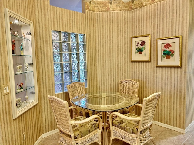 dining room with tile patterned floors, wallpapered walls, and baseboards