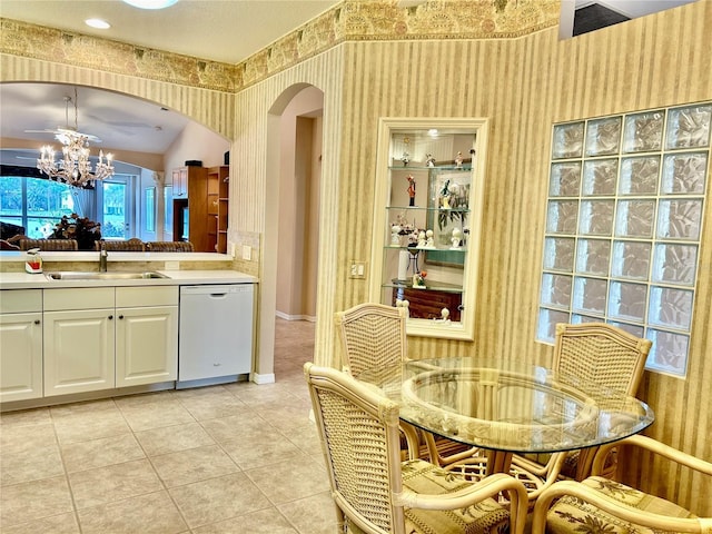 dining area with light tile patterned floors, arched walkways, a chandelier, and wallpapered walls