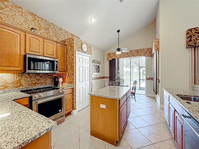 23901 Waverly Cir, Venice, FL 34293 - kitchen featuring stainless steel appliances, a kitchen island, light stone counters, a ceiling fan, and decorative backsplash