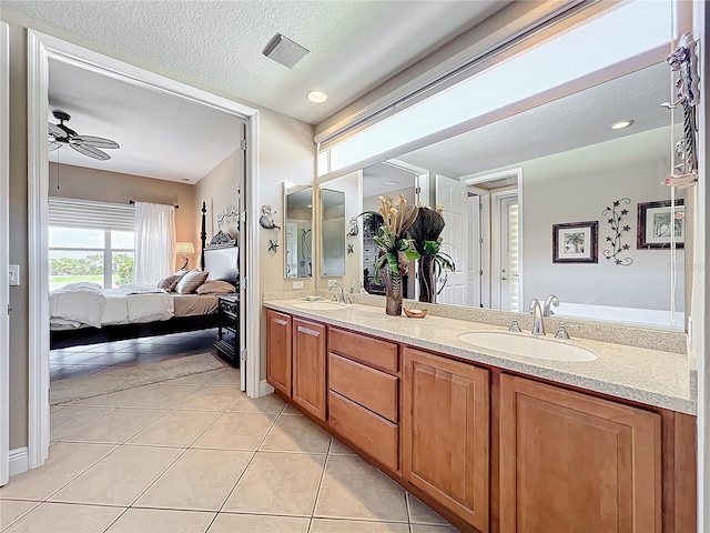 23901 Waverly Cir, Venice, FL 34293 - ensuite bathroom with double vanity, ceiling fan, tile patterned flooring, and a textured ceiling
