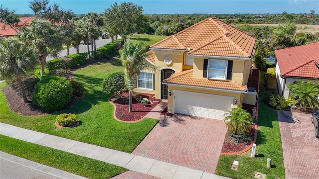 23901 Waverly Cir, Venice, FL 34293 - mediterranean / spanish-style home featuring a tiled roof, decorative driveway, stucco siding, and a front lawn