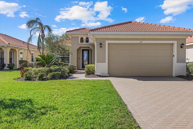 mediterranean / spanish house with a tiled roof, a front yard, stucco siding, decorative driveway, and a garage