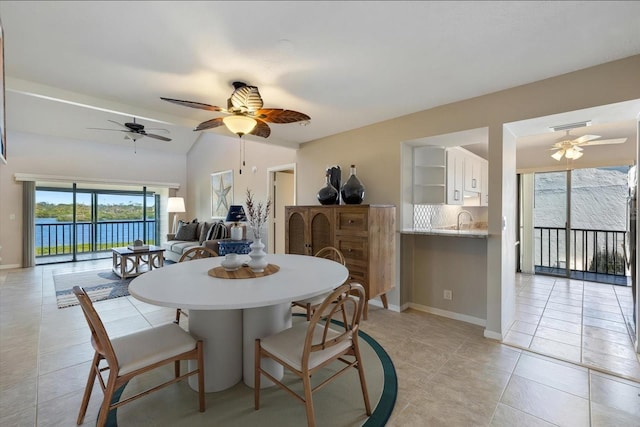 dining area featuring visible vents, baseboards, ceiling fan, vaulted ceiling, and light tile patterned floors