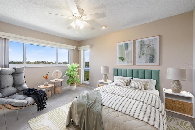 tiled bedroom featuring a textured ceiling, baseboards, and a ceiling fan