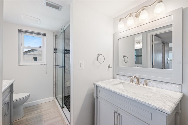 bathroom with vanity, toilet, visible vents, and a stall shower