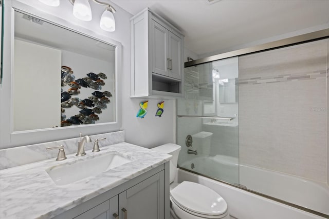 bathroom with shower / bath combination with glass door, toilet, and vanity