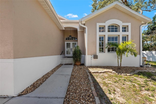 property entrance featuring french doors and stucco siding