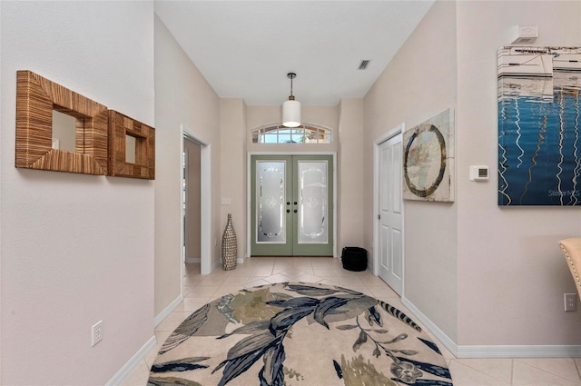 foyer with light tile patterned floors, visible vents, baseboards, and french doors