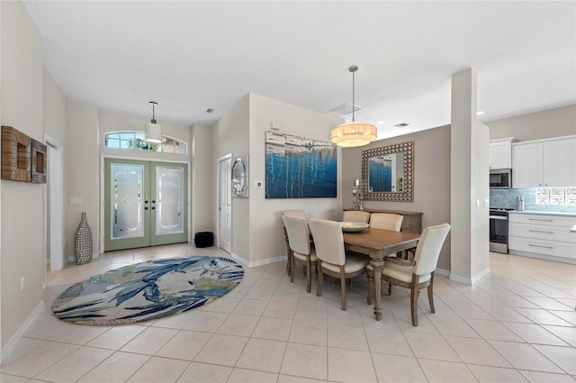 dining room featuring light tile patterned floors, french doors, and baseboards