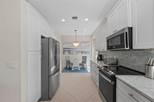 kitchen featuring light tile patterned floors, visible vents, appliances with stainless steel finishes, white cabinetry, and backsplash