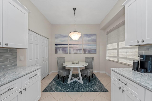 dining area featuring light tile patterned floors and baseboards