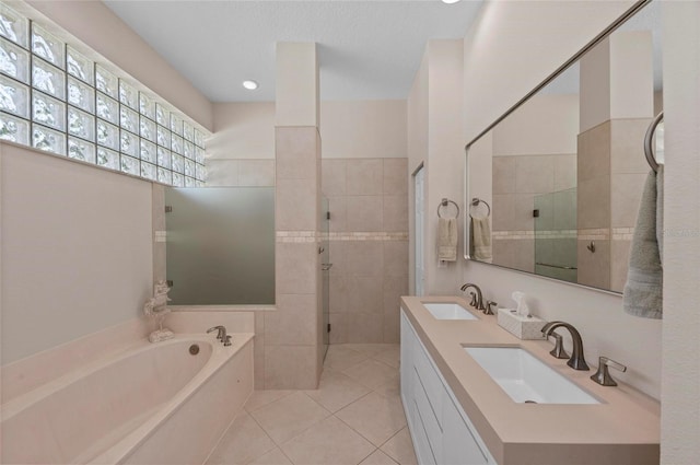 full bathroom with tile patterned floors, a garden tub, a stall shower, and a sink