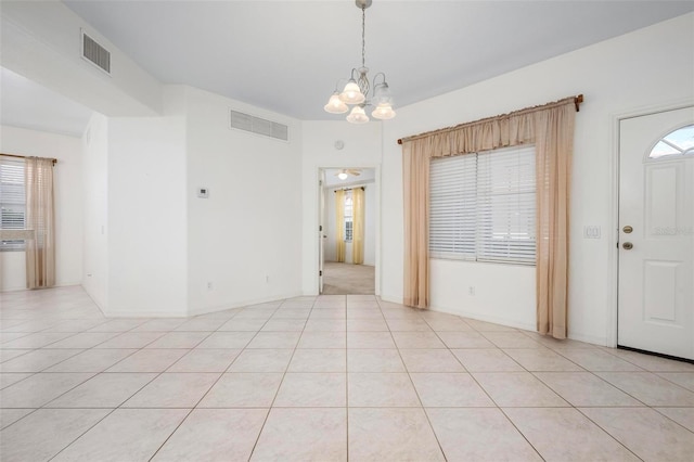 spare room featuring an inviting chandelier, light tile patterned flooring, and visible vents