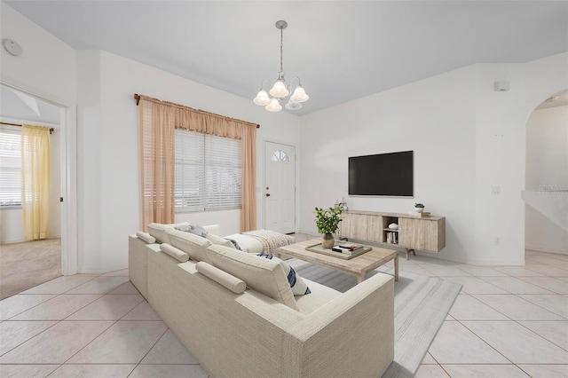 living room featuring an inviting chandelier, light tile patterned floors, and arched walkways