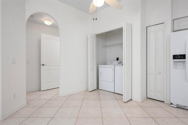 laundry room with light tile patterned floors, a ceiling fan, laundry area, arched walkways, and independent washer and dryer