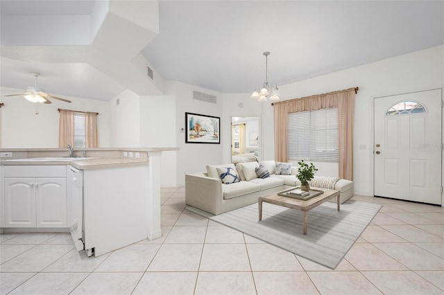 living area featuring light tile patterned floors, visible vents, and ceiling fan with notable chandelier