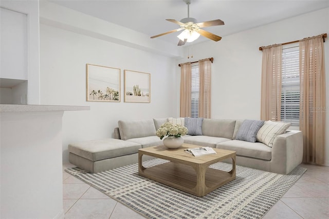 living area featuring light tile patterned floors, a healthy amount of sunlight, and ceiling fan