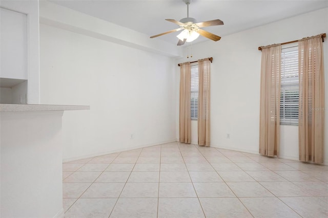 unfurnished room featuring plenty of natural light, light tile patterned floors, and ceiling fan