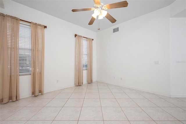 spare room with light tile patterned floors, visible vents, and a ceiling fan