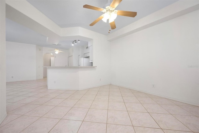 unfurnished room featuring arched walkways, light tile patterned floors, and a ceiling fan