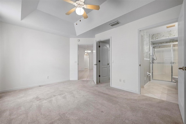 unfurnished bedroom featuring a tray ceiling, carpet, visible vents, and baseboards