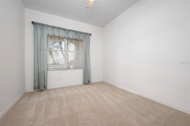 spare room with lofted ceiling, carpet flooring, baseboards, and ceiling fan