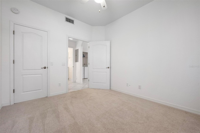 unfurnished bedroom featuring visible vents, light colored carpet, baseboards, and ceiling fan